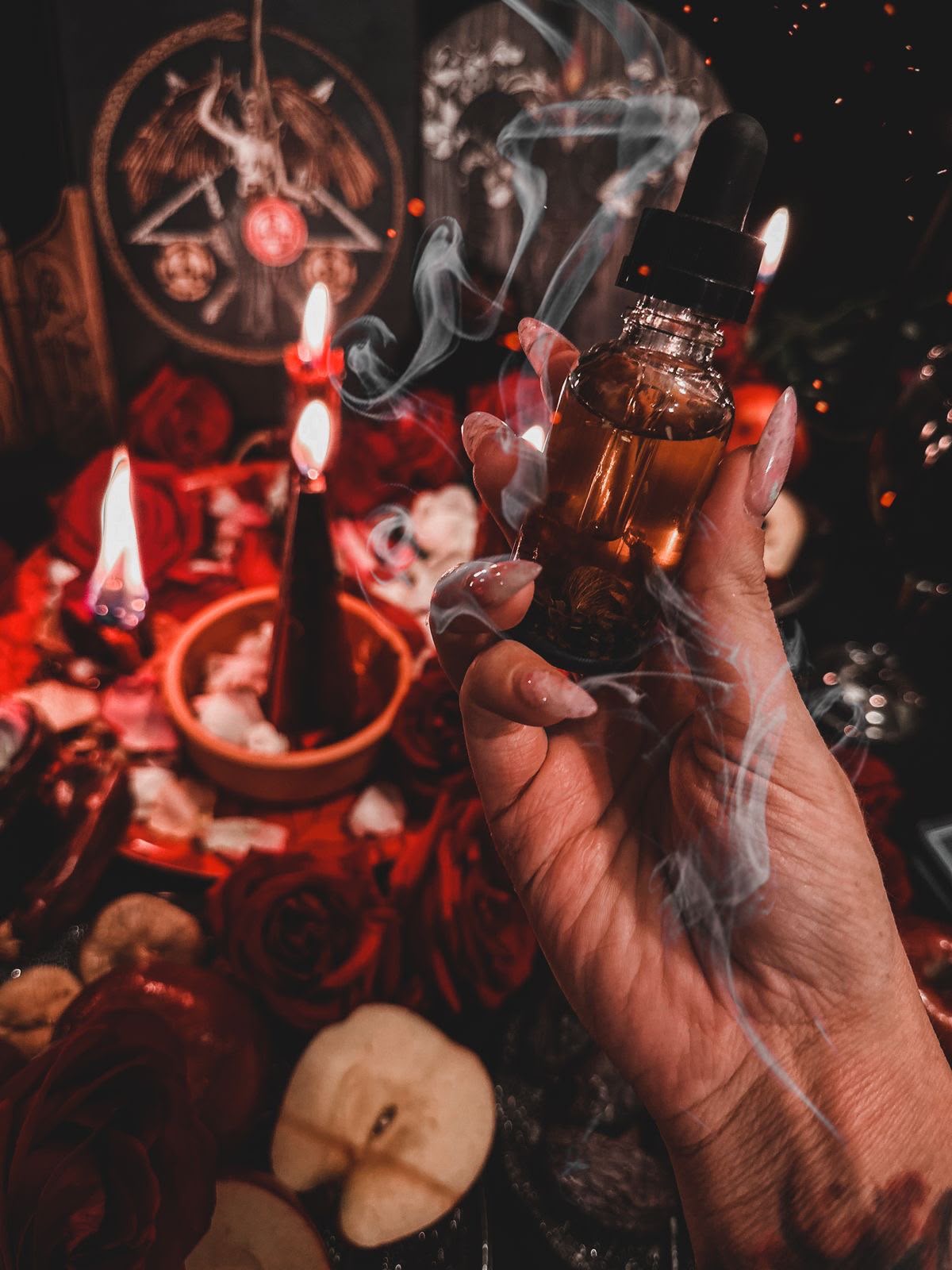 Mâinile Andrei Aida deasupra lumânărilor roșii, în timpul unui ritual