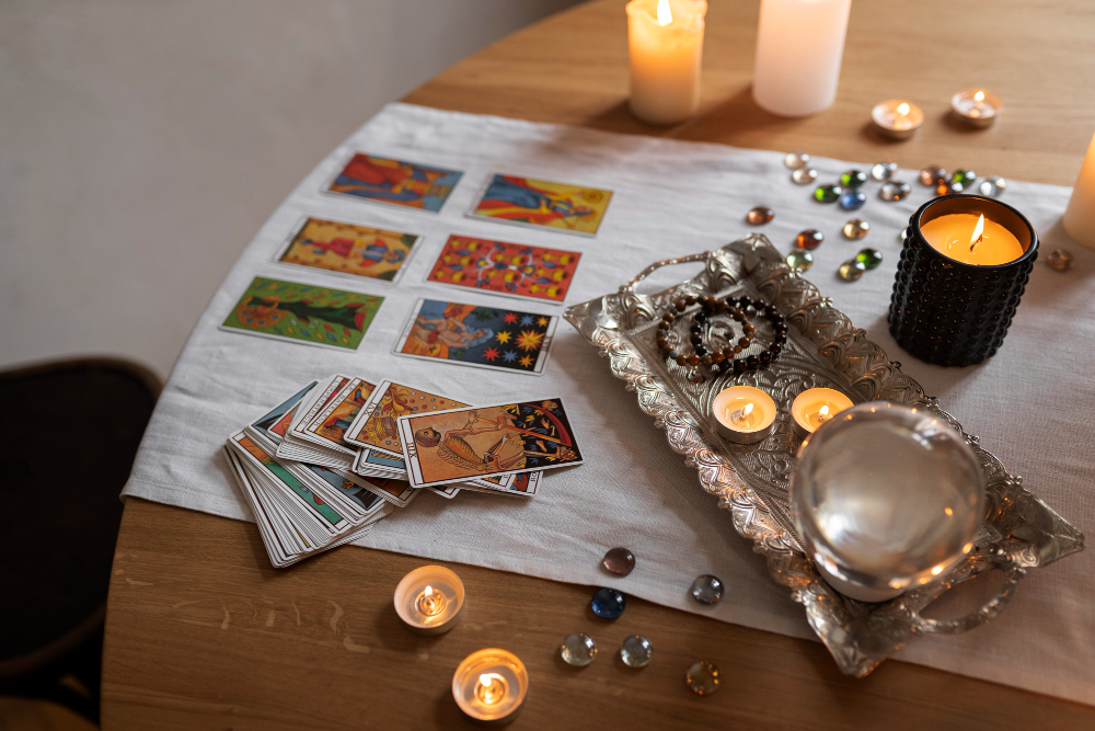 Desfășurare de cărți de tarot pe masă, alături de lumânare